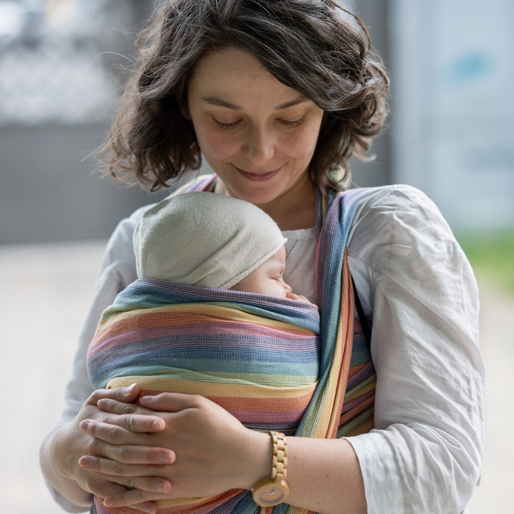 Mama obejmuje niemowlę podczas naturalnej sesji rodzinnej w Warszawie