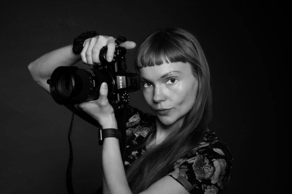 Fotografka trzyma aparat podczas sesji wizerunkowej w Warszawie